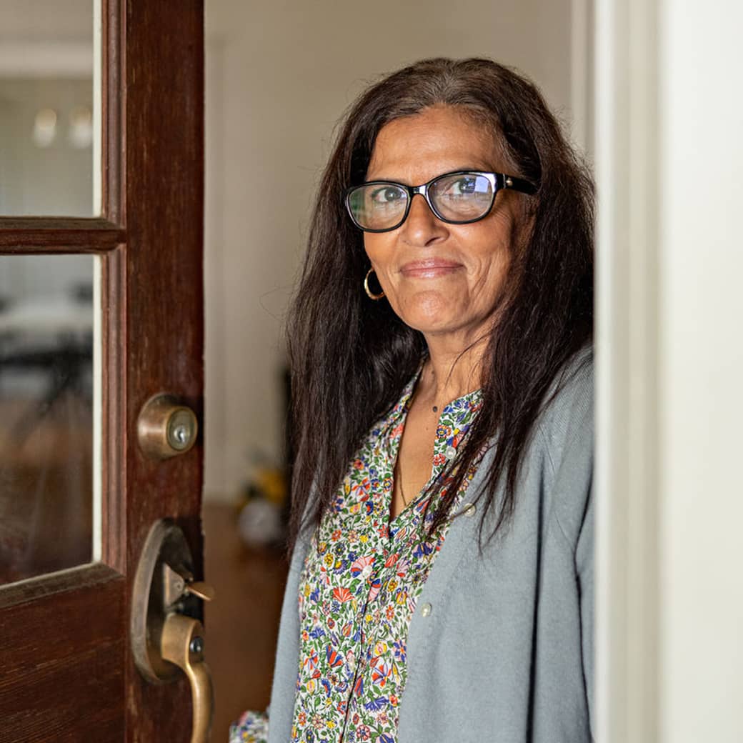 A person looking out from their doorway.