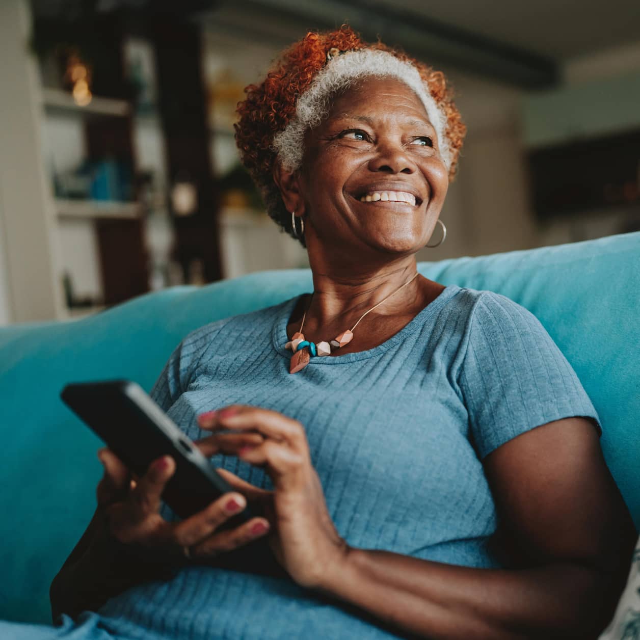 A smiling older person holding a cell phone.