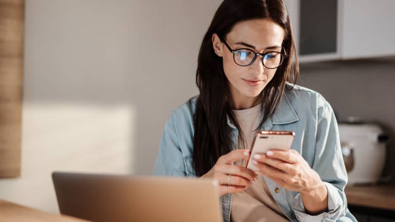 A woman looking up specialty medications on her cell phone.