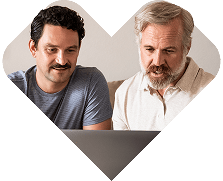 Two people looking at a laptop screen together.