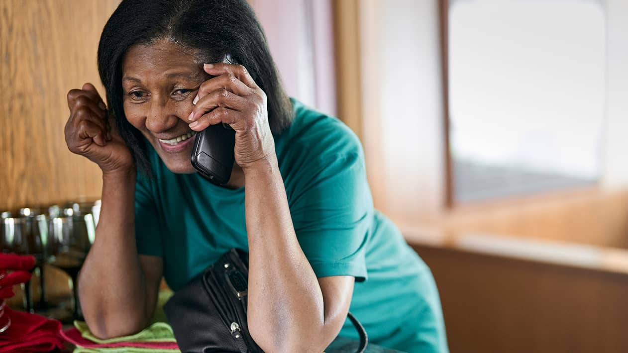 A person smiling while on their cellphone with their CareTeam.