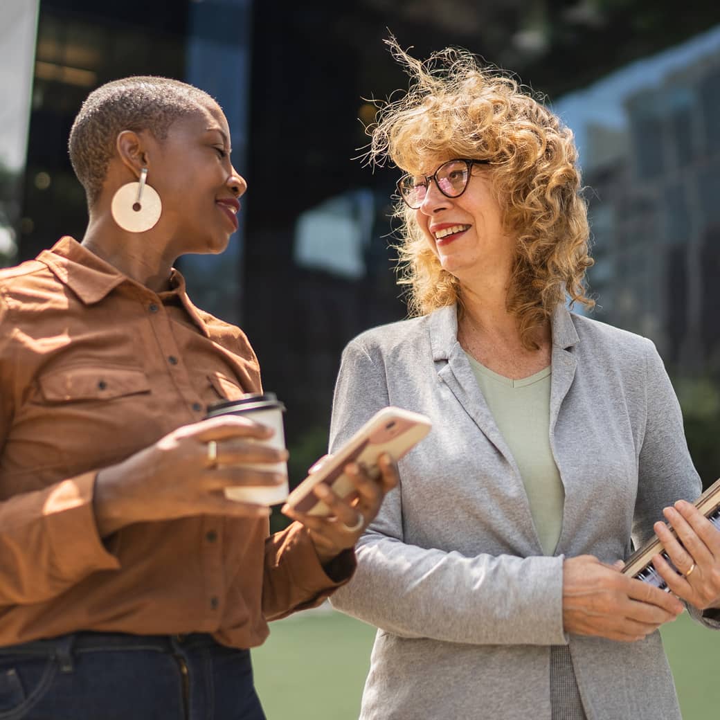 Two colleagues in conversation walking outdoors.