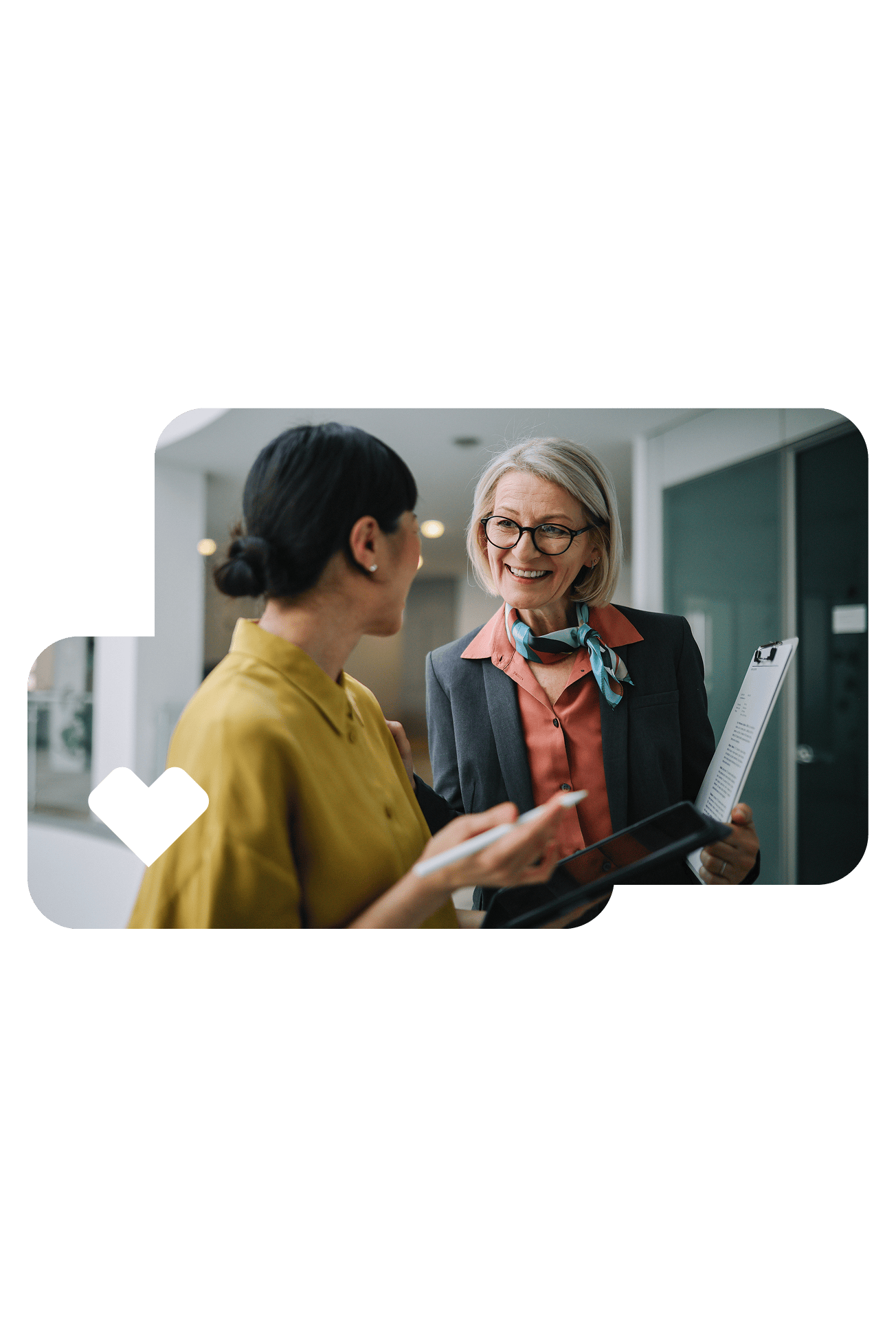 Two colleagues in conversation outside a conference room.