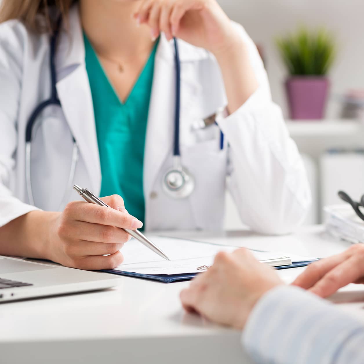 A practitioner making notes for a conversation with a patient