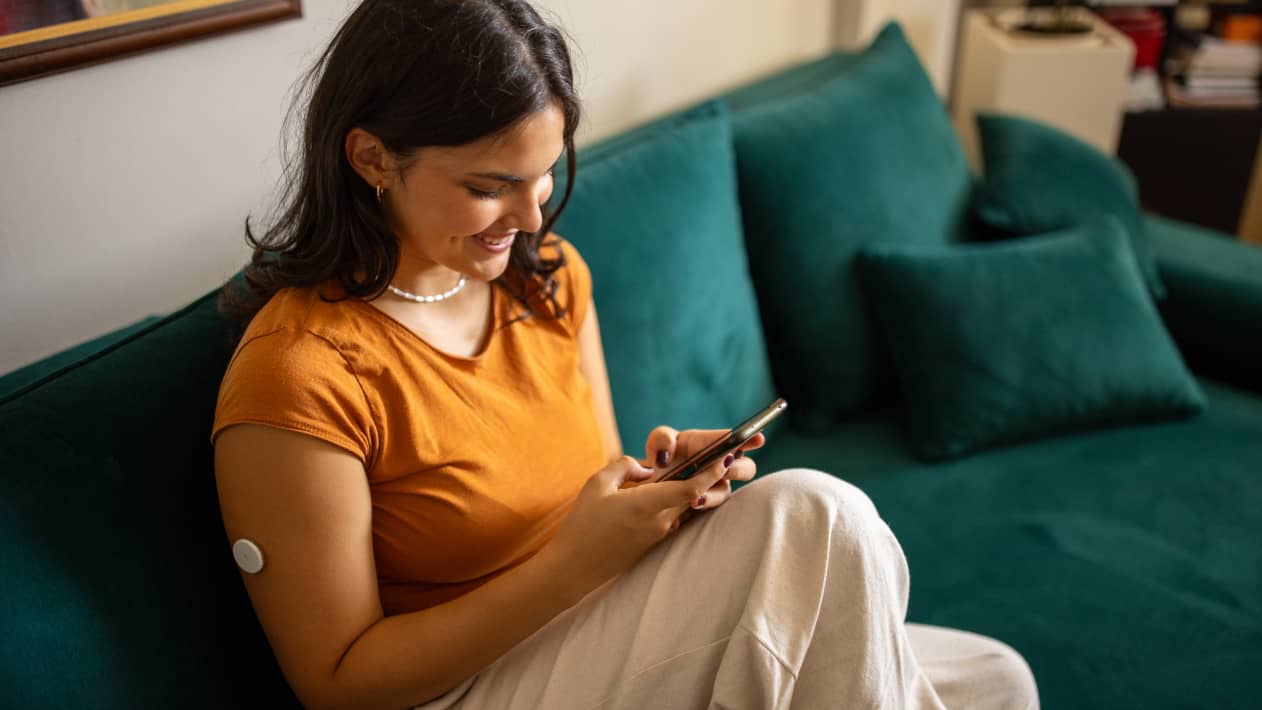 A person sitting on the sofa and texting on their cell phone
