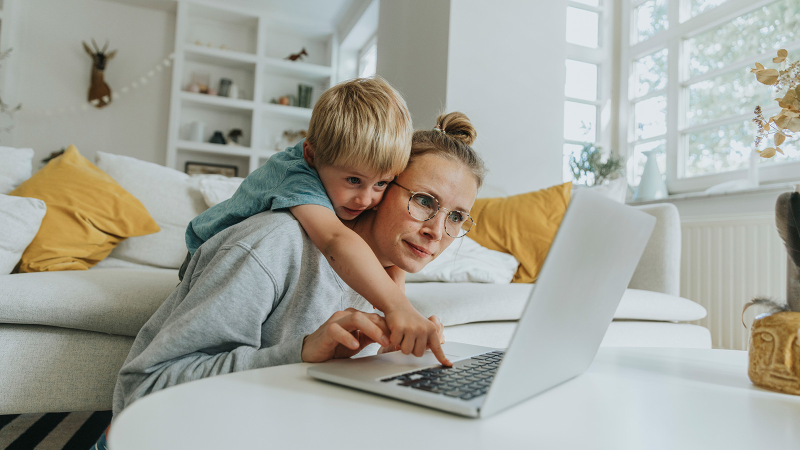 Parent and child using a laptop together at home.
