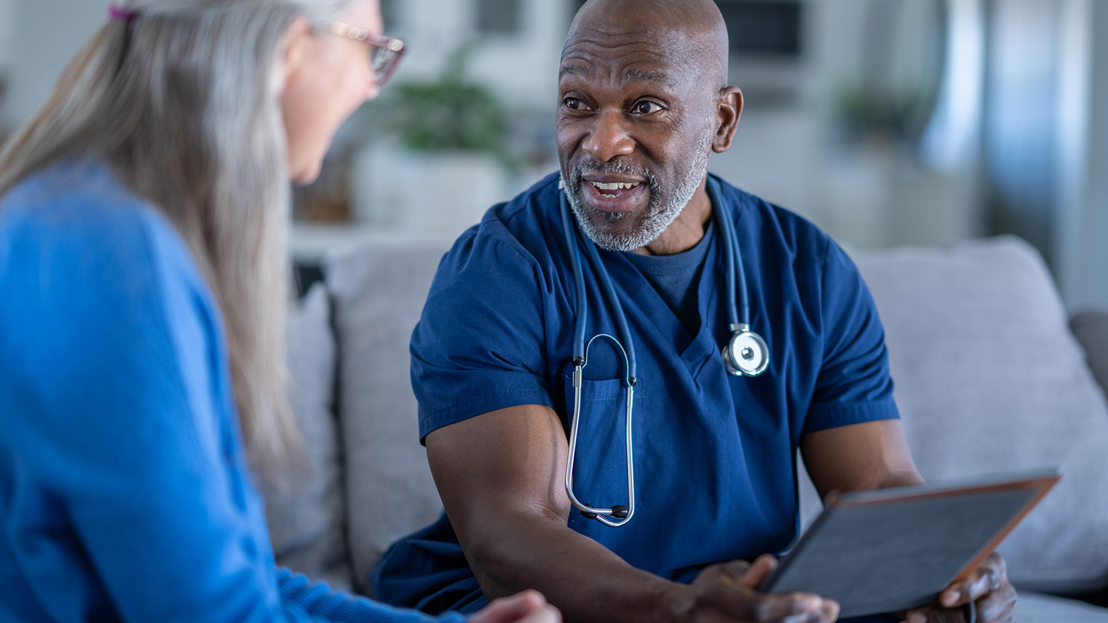 Healthcare professional in discussion with a patient while seated.