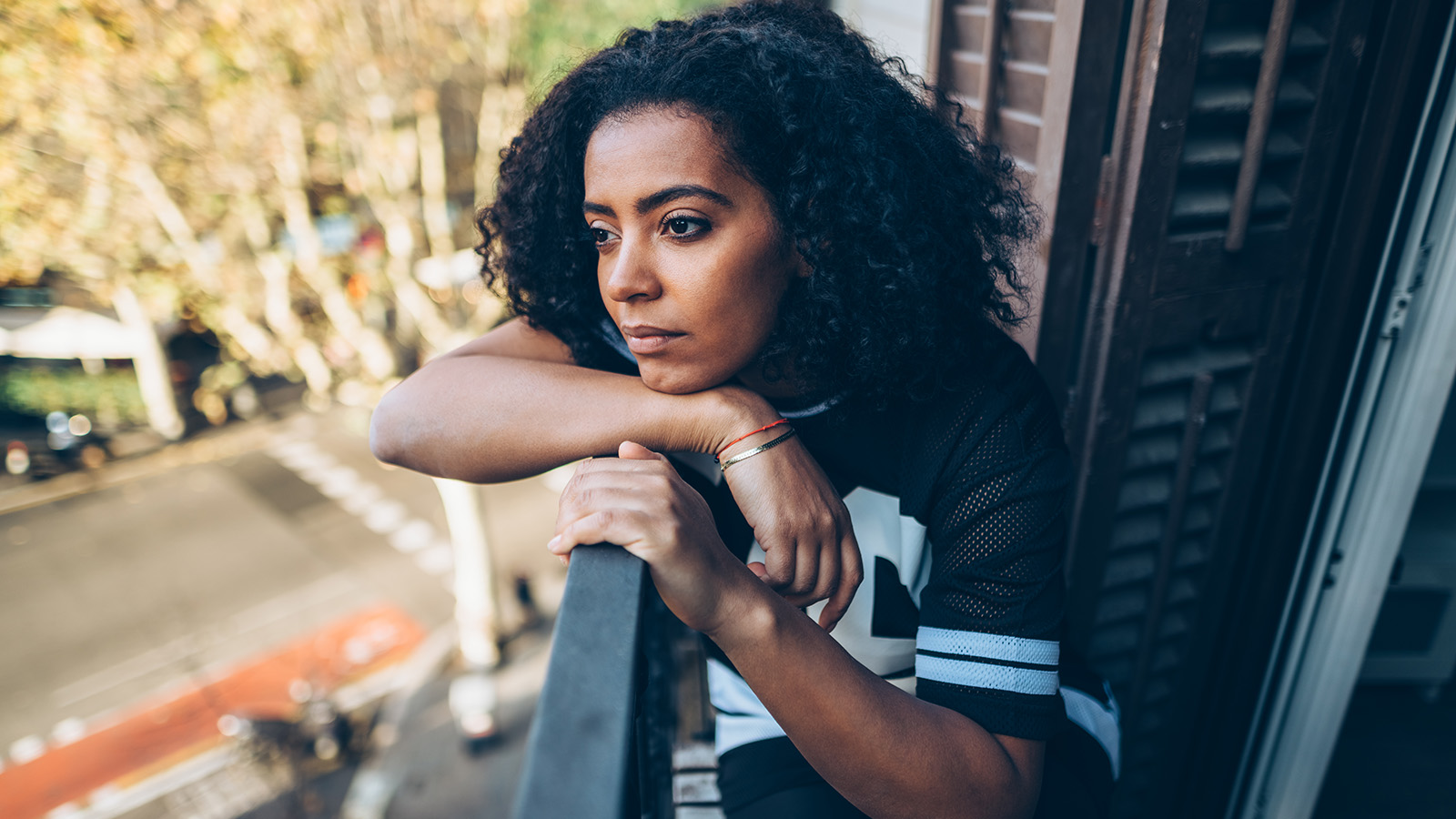A person resting their arms on a balcony railing