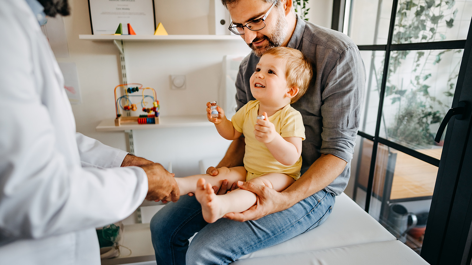 Parent holding a child during a medical check-up
