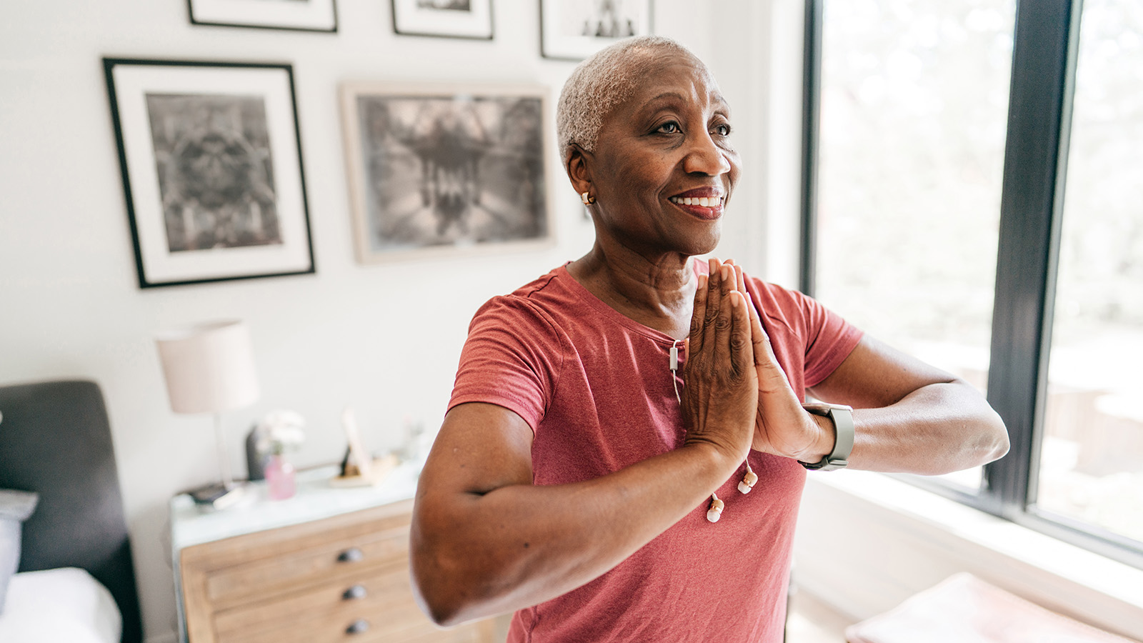 A woman is performing a yoga pose at home, focusing on her practice