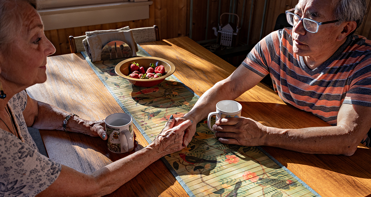Two people sitting together in a bright indoor setting.